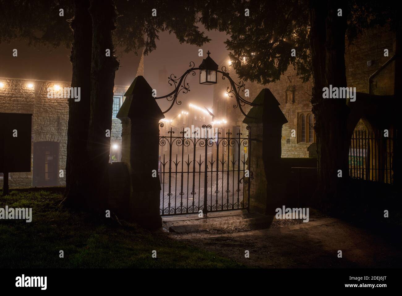 St Edwards church gates and christmas lights along church street in the mist at night. Stow on