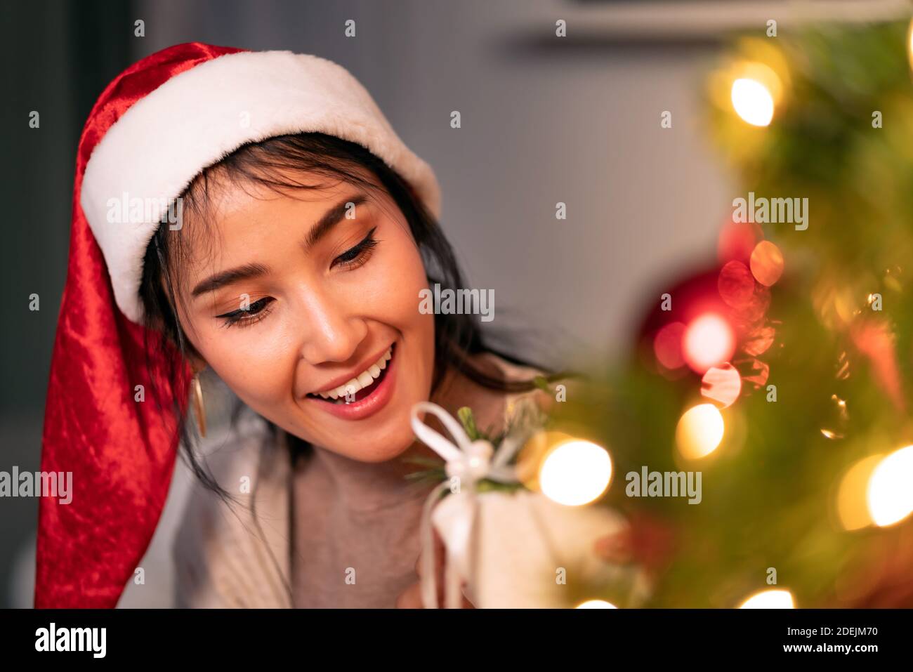 Beautiful asian woman holding Christmas ornament for decorate on christmas tree preparing for season greeting of merry christmas and happy holiday. Stock Photo