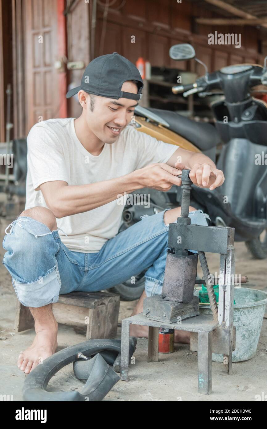 tire patcher holds the press before patching the leaky inner tube in a