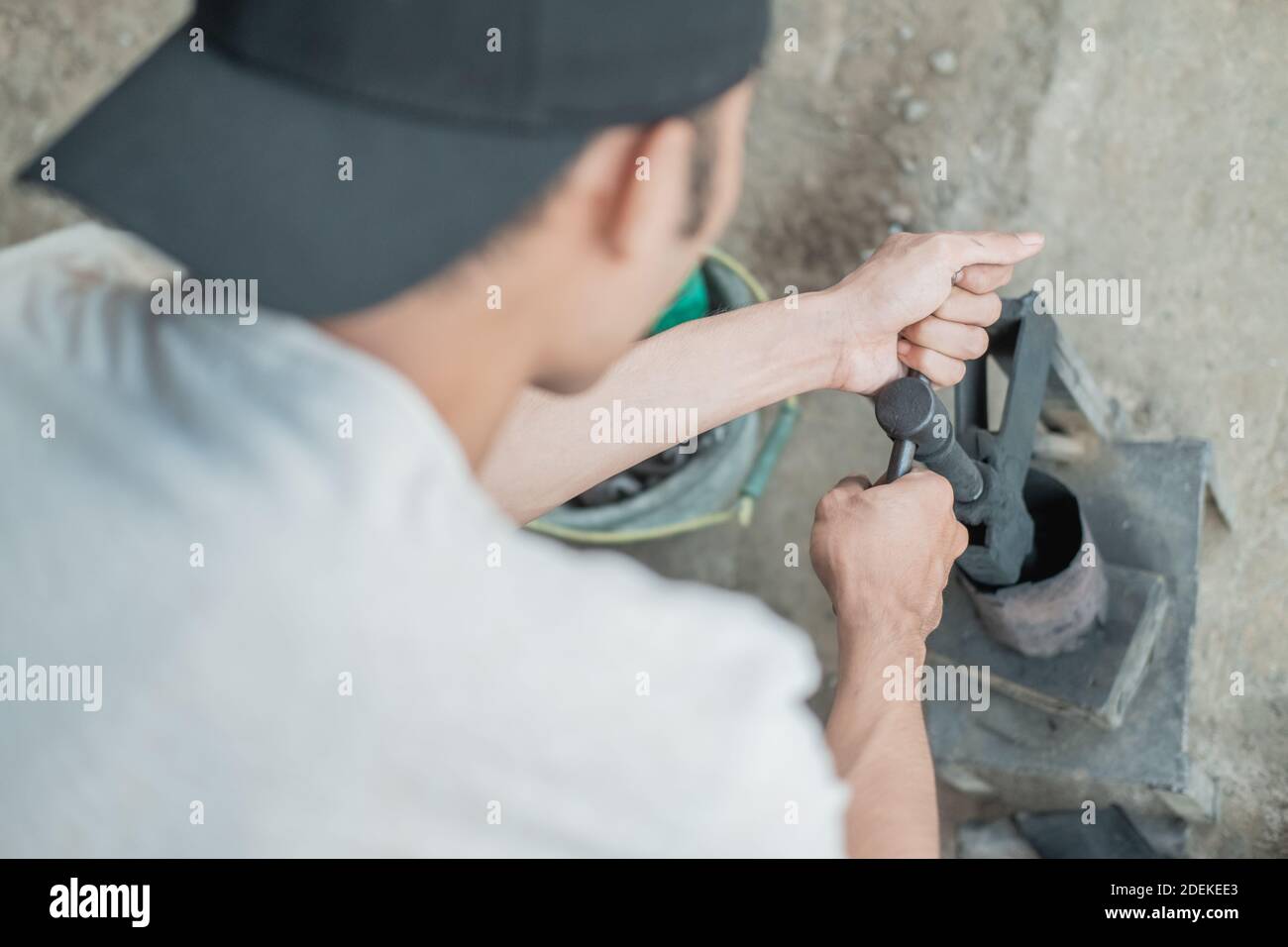 close up of tire patcher rotates the handle of a traditional press