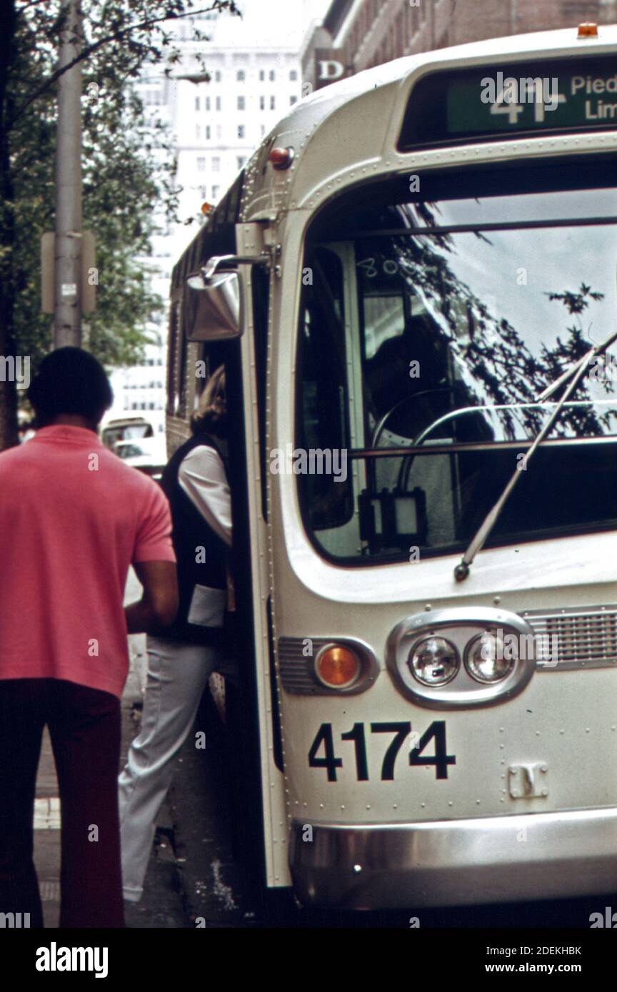 Passengers board a Metropolitan Atlanta Rapid Transit Authority (MARTA) bus in downtown Atlanta; Georgia. In 1974 the system carried 73;727;000 passengers; an increase of 27 percent since 1970.  ca. 1973-1974 Stock Photo