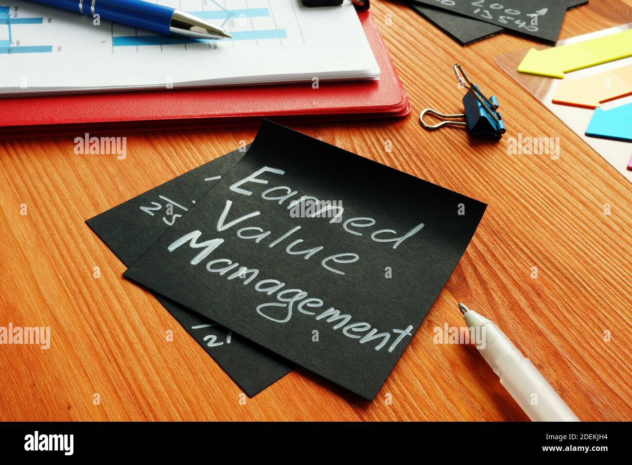Memo for Earned Value Management EVM on the black sheet. Stock Photo