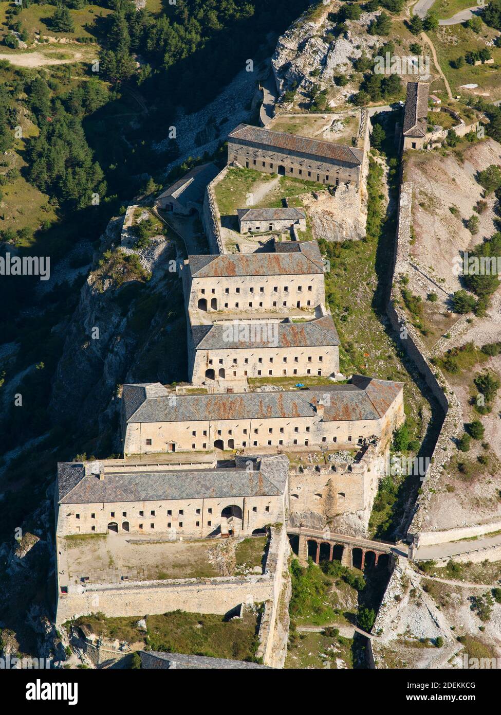 AERIAL VIEW. Military barracks on a steep limestone ridge above the Arc Valley. Victor-Emmanuel Fort, Aussois, Savoie, Auvergne-Rhône-Alpes, France. Stock Photo