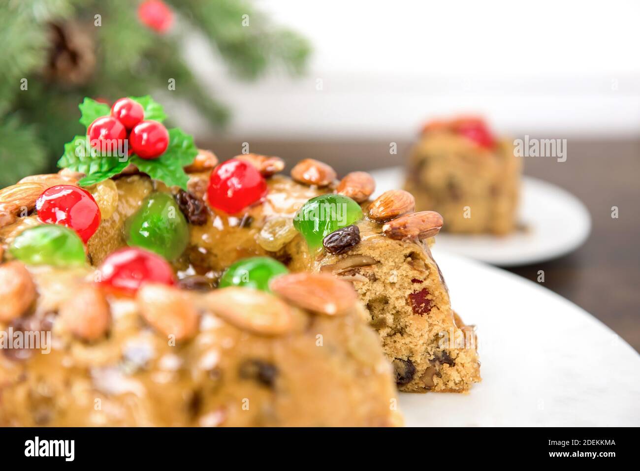 Colorful delicious homemade Christmas fruit cake on white platter