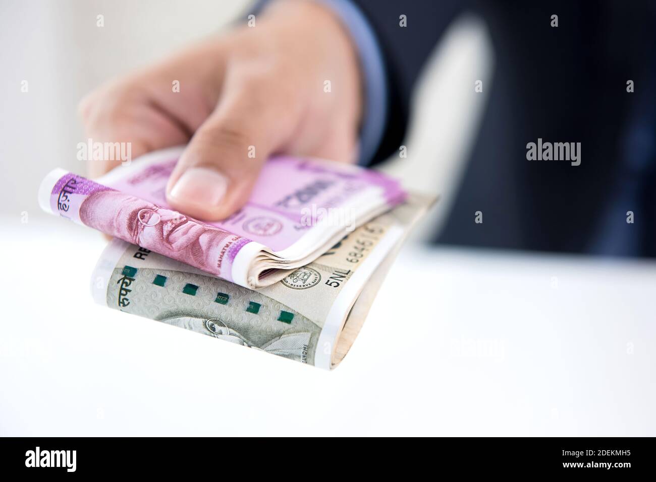 Businessman giving money in the form of Indian Rupees for services rendered Stock Photo