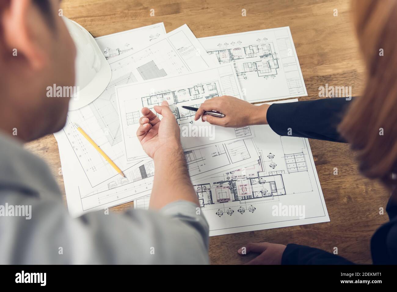 Engineer and architect discussing about blueprint layout design of  electricity plan at the construction site Stock Photo