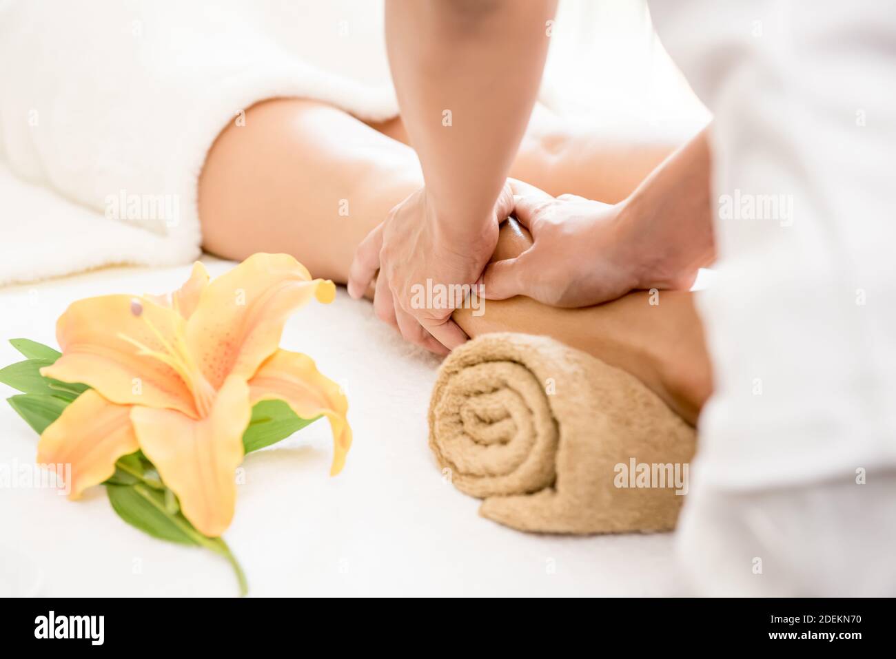 Professional therapist giving reflexology relaxing Thai leg massage treatment to a woman in spa Stock Photo
