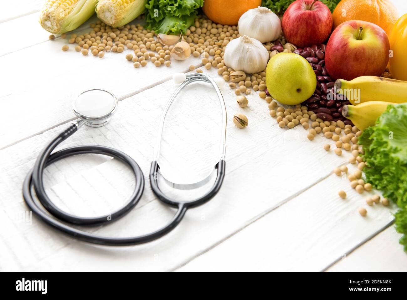 Medicinal and healthy food, mixed fruits and nuts, with stethoscope on white wood table Stock Photo