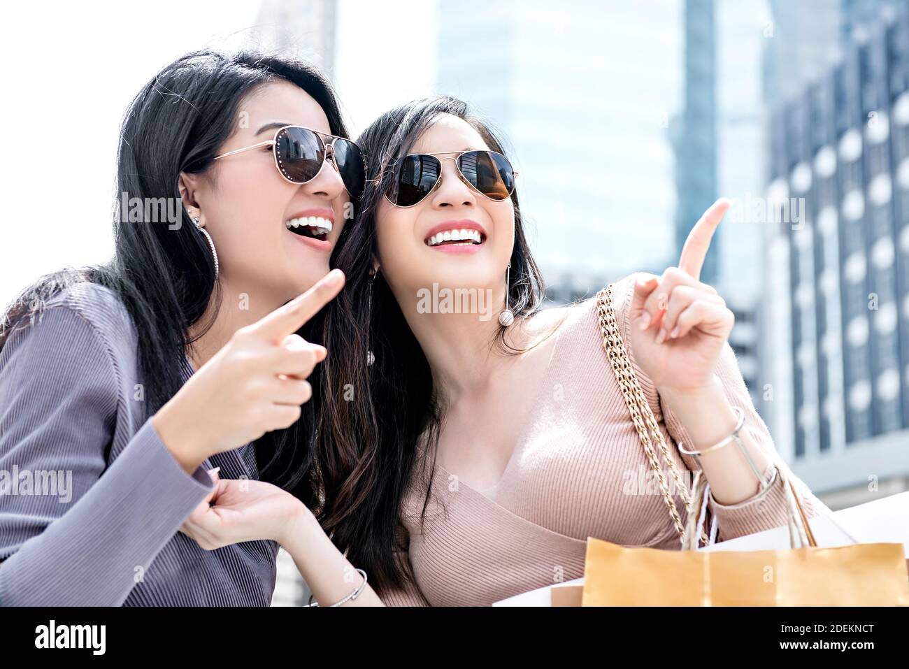 Beautiful young Asian woman friends enjoying traveling and shopping in the city during summer holiday sales season Stock Photo