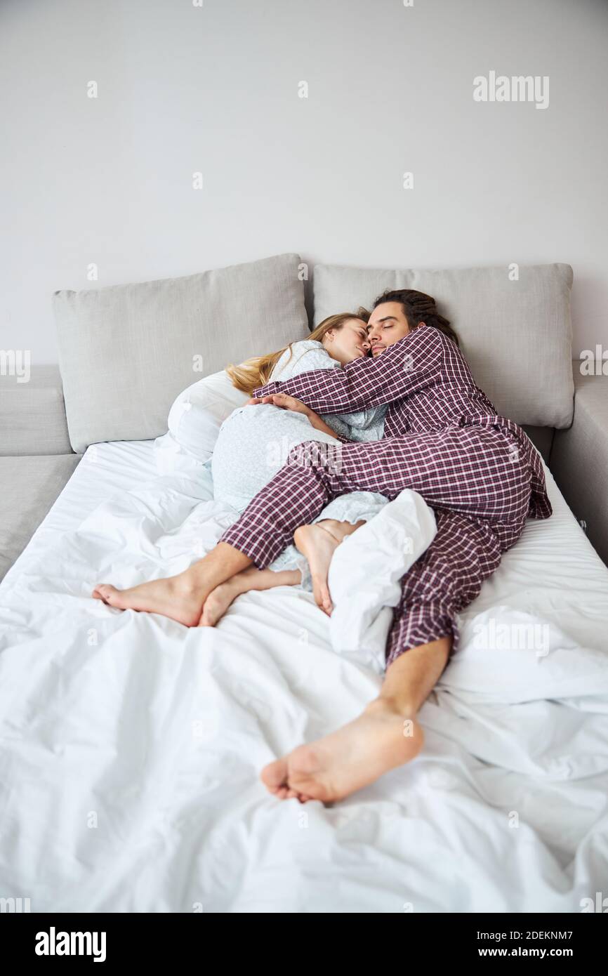 Beautiful couple in love cuddling and sleeping in bed Stock Photo - Alamy