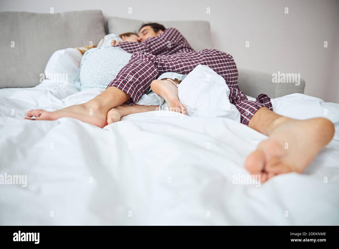 Happy young couple sleeping together in bed Stock Photo - Alamy