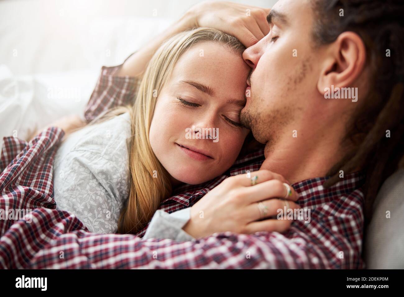 Beautiful young woman sleeping in boyfriend arms Stock Photo - Alamy
