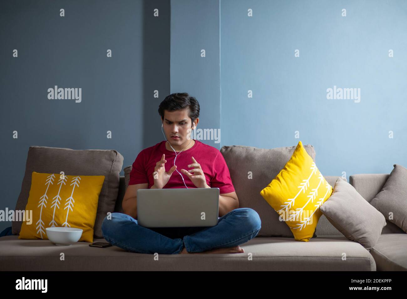 YOUNG COLLEGE STUDENT GETTING HIS DOUBTS CLEARED IN DURING ONLINE CLASS SESSION Stock Photo