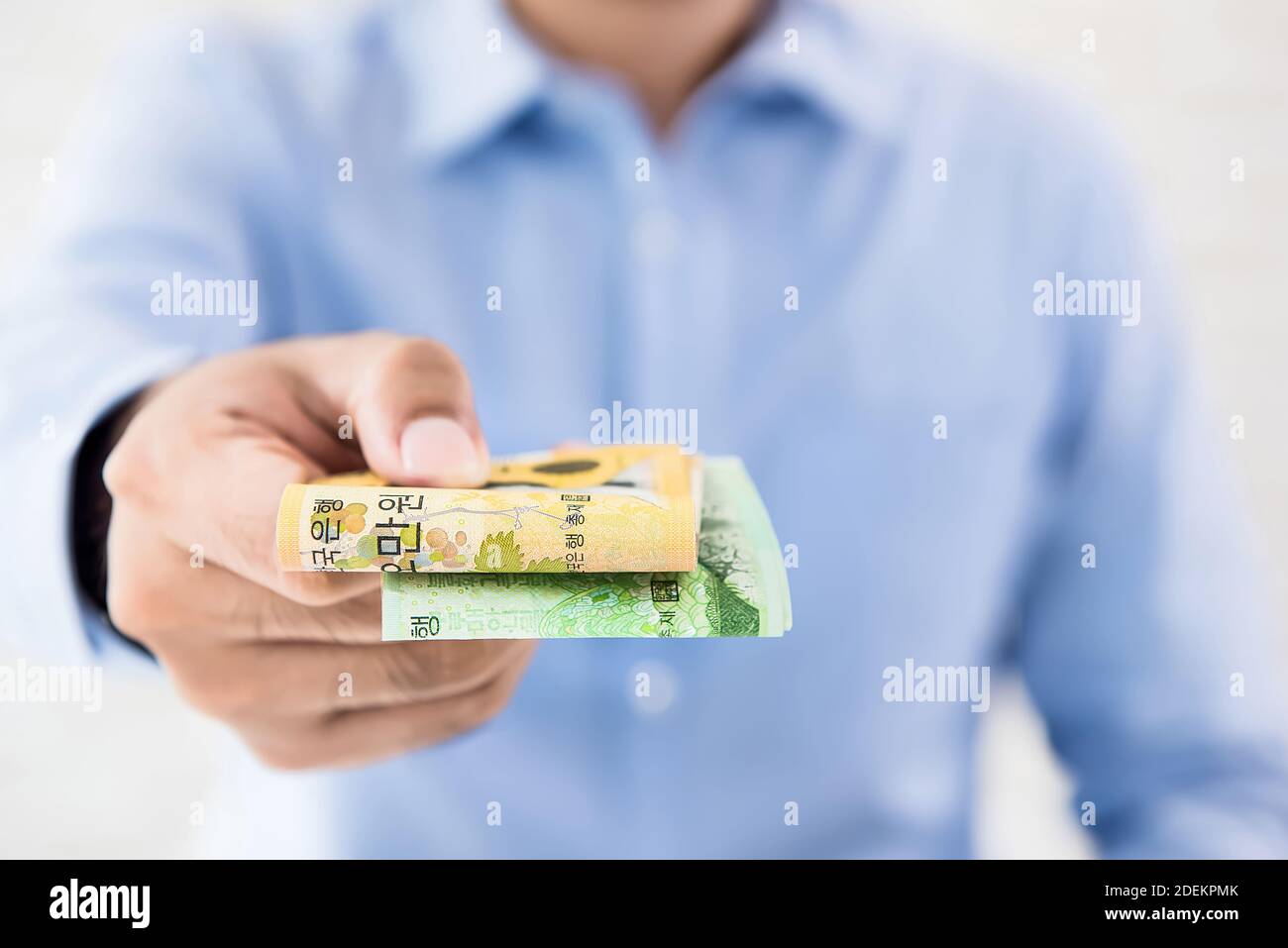 Casual businessman giving money in the form of South Korean WON currency for service rendered Stock Photo