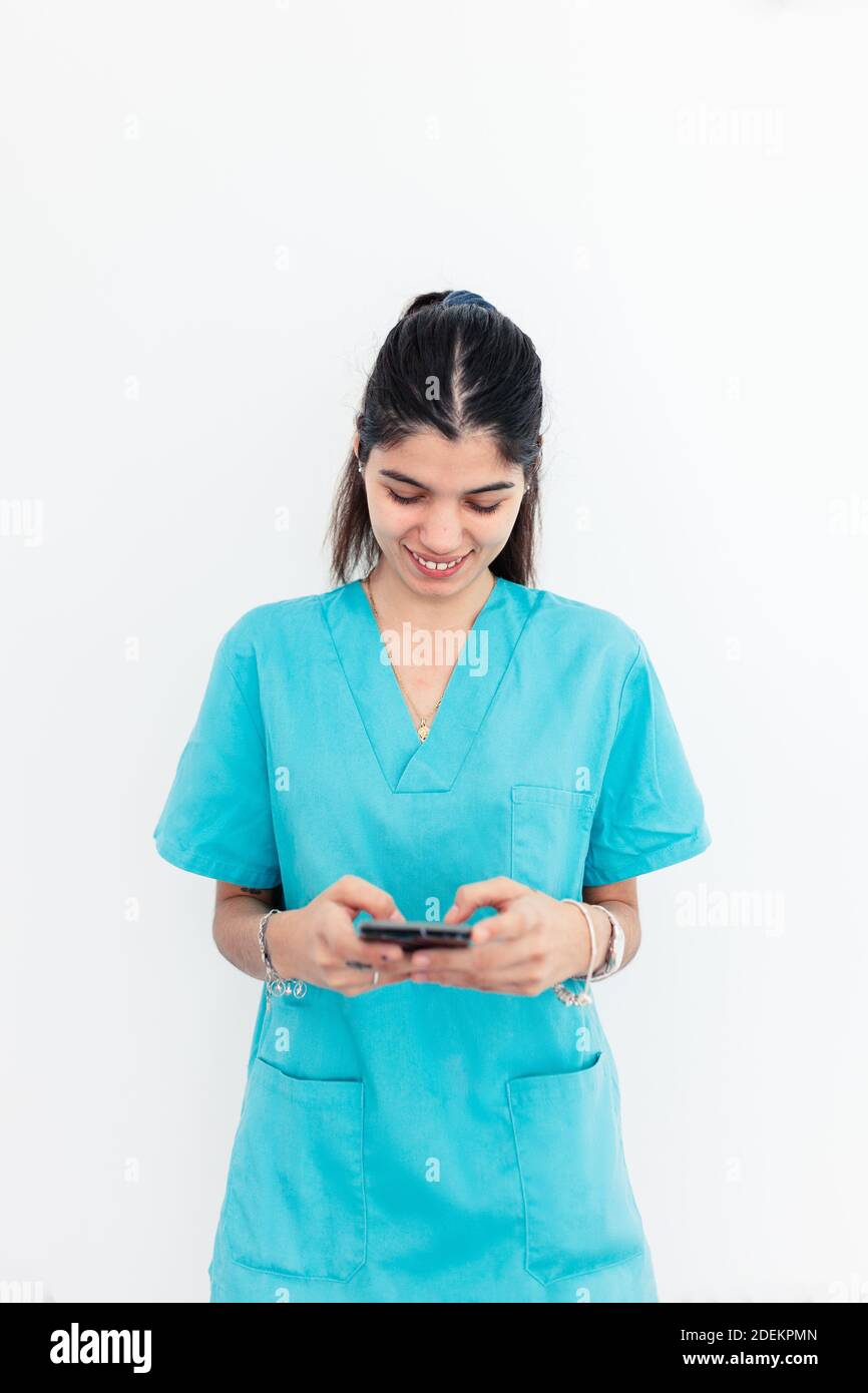Nurse using smartphone standing in the clinic with withe background Stock Photo
