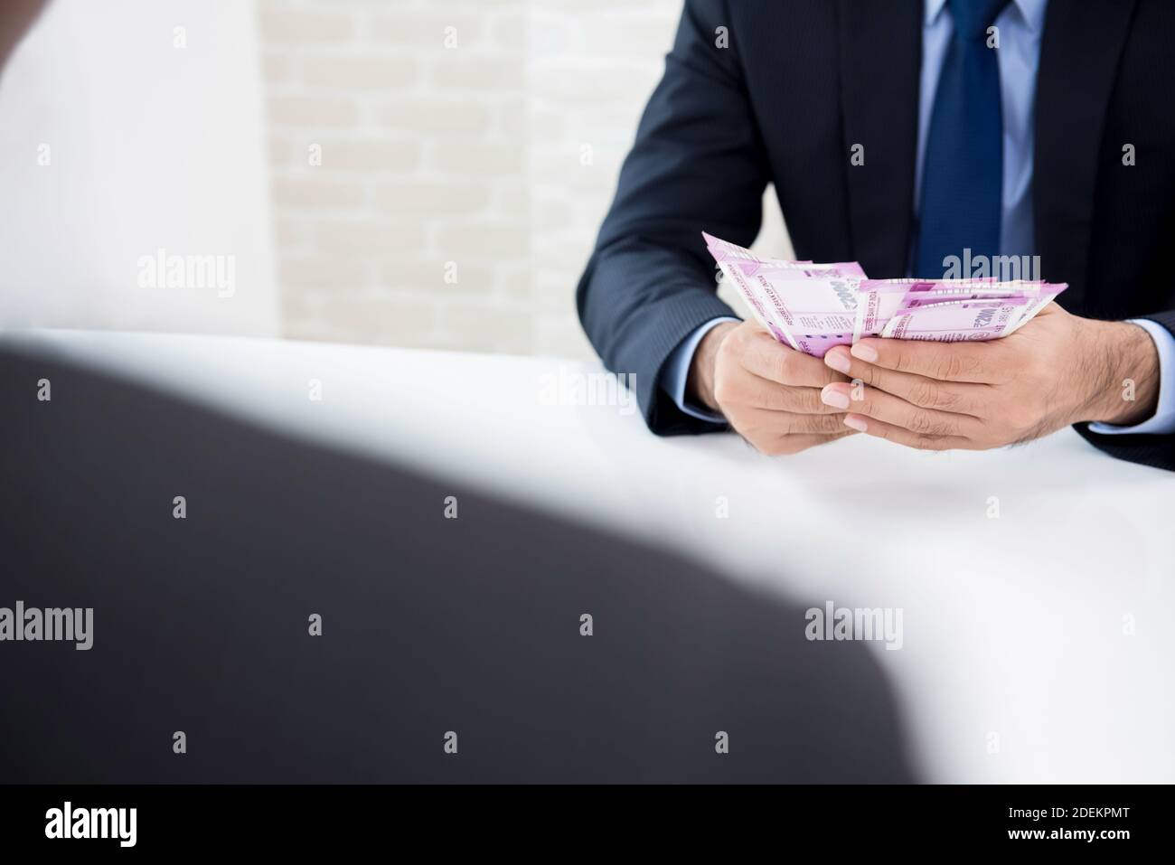 Businessman counting money, Indian Rupee currency, just received from his partner after making agreement Stock Photo