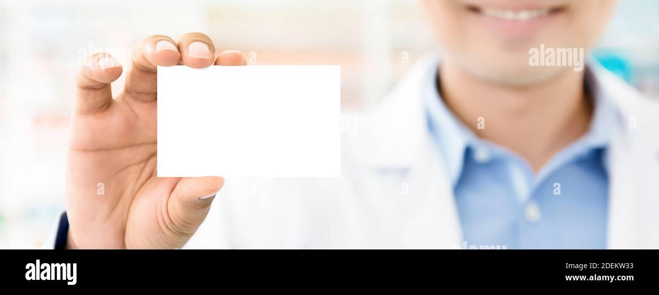 Smiling doctor or medical worker in hospital showing business card with blank space for text - panoramic web banner Stock Photo
