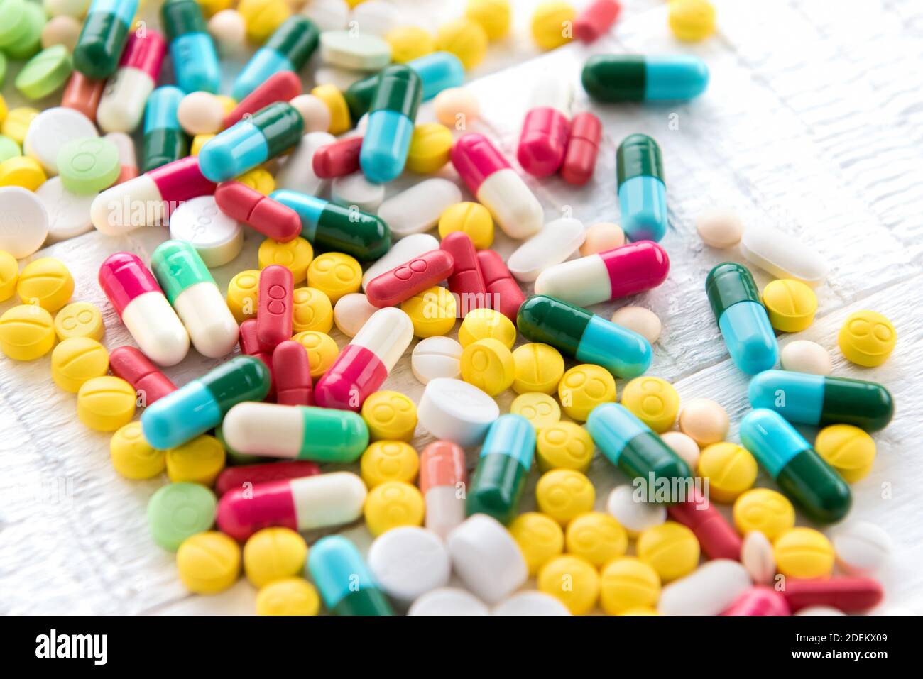 Mixed colorful pharmaceutical drugs and medicine in pill and capsule form on white table Stock Photo