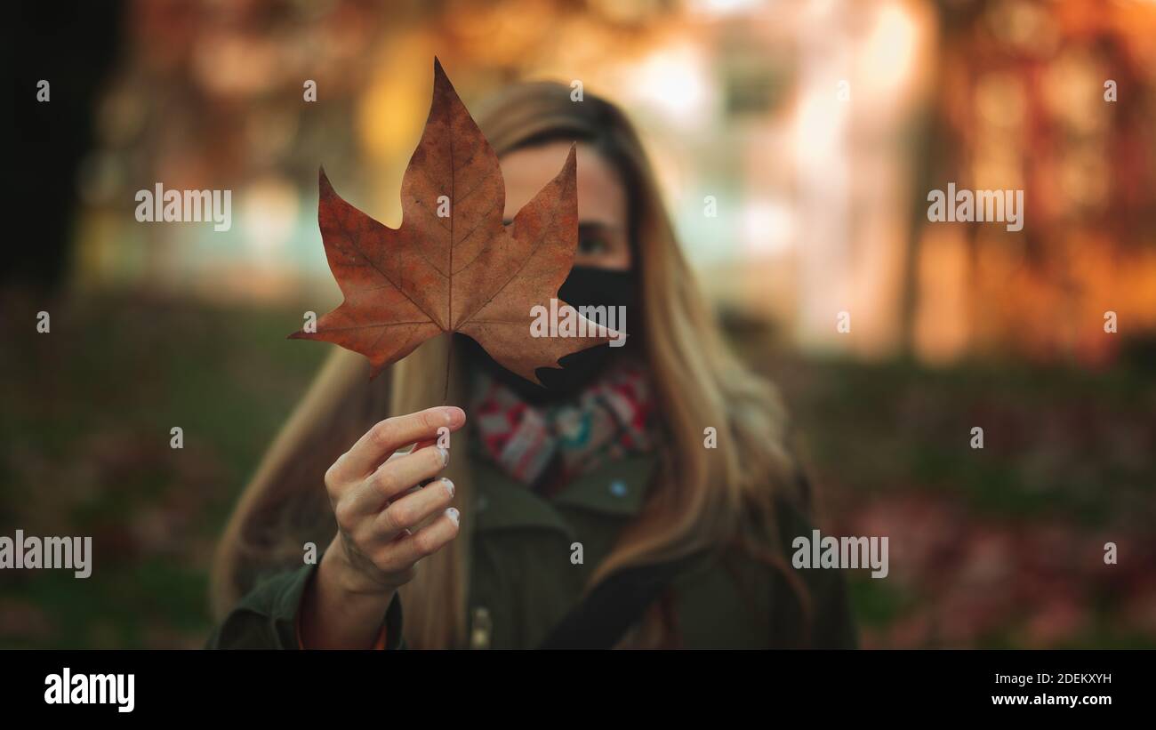 Young woman holding a dry leaf Stock Photo
