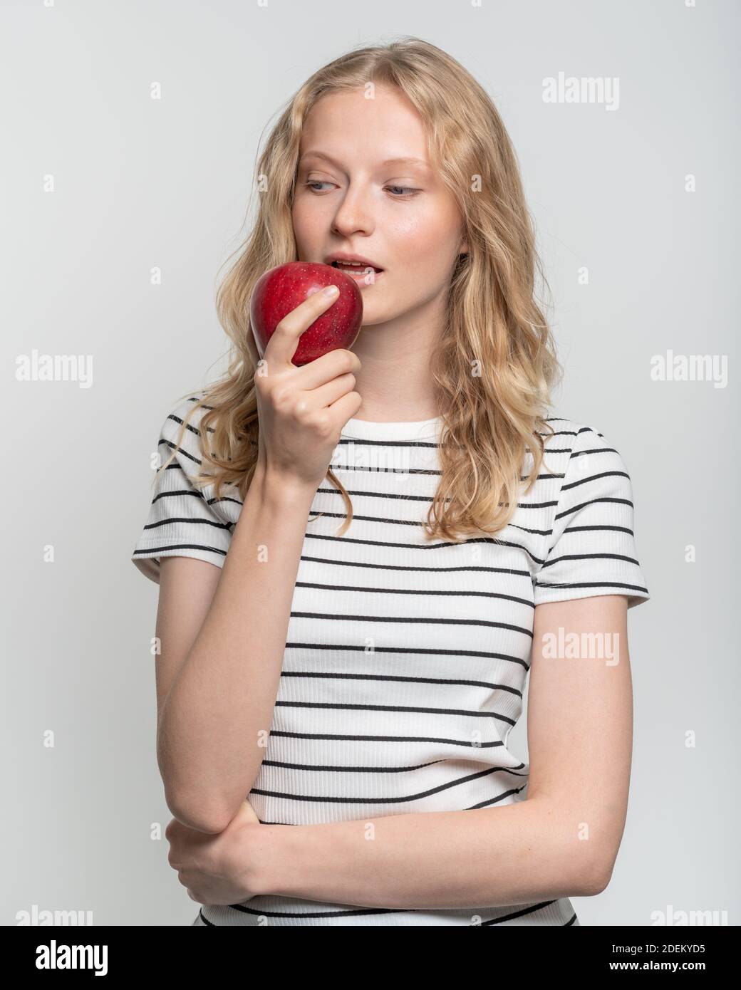 Portrait of young smiling woman bitting red apple. Fresh face, natural beauty Stock Photo