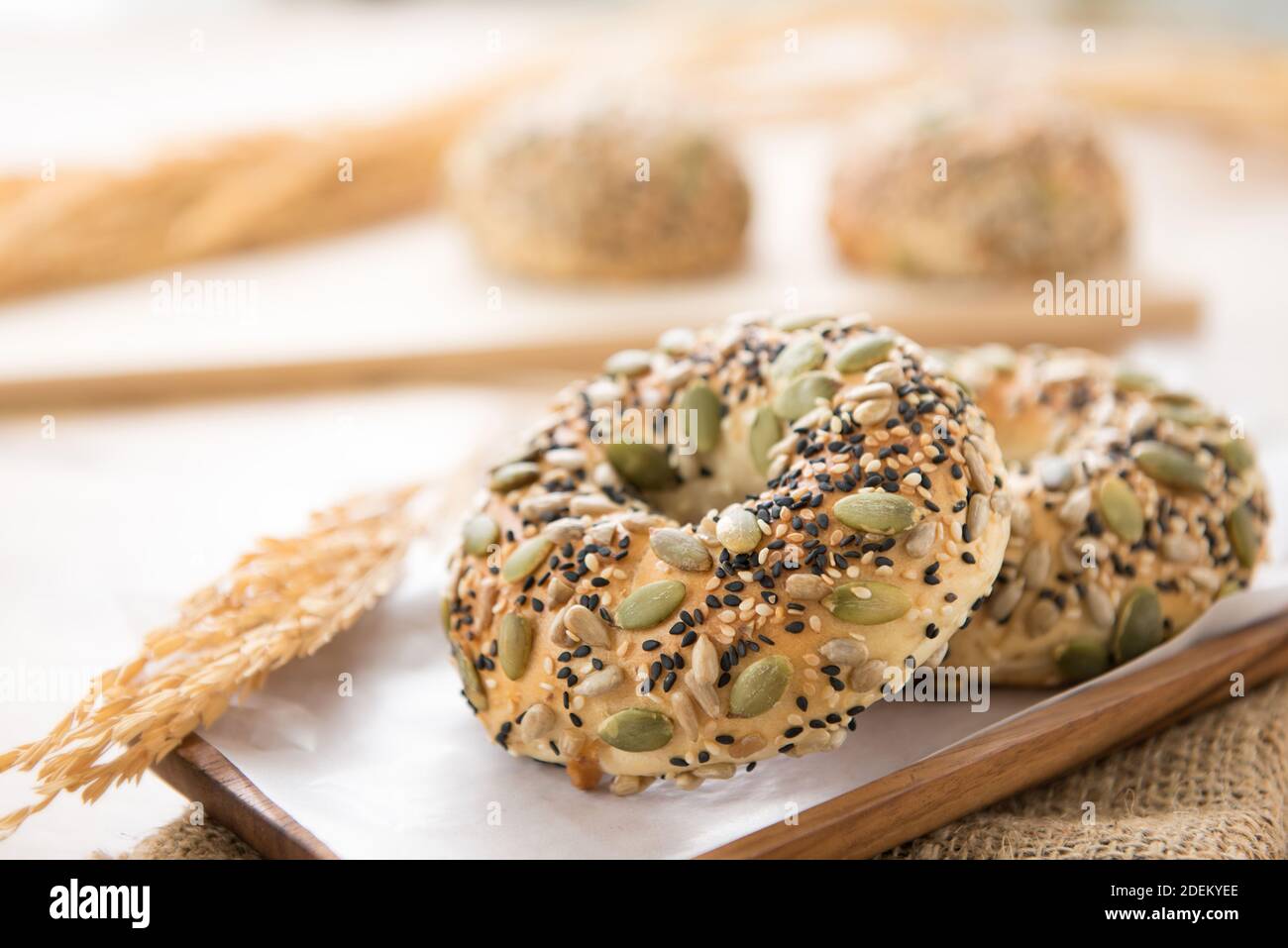 A healthy oven baked multigrain doughnut buns served on a wooden plate in a bakery Stock Photo
