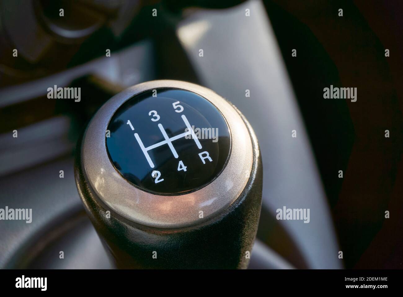 Closeup of manual transmission gear shift on dark background. Stock Photo