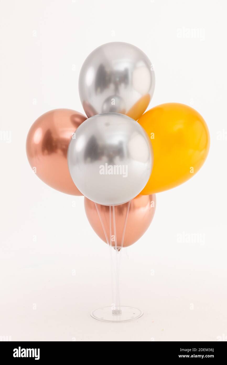Silver, rose gold and gold metallic balloons on white background Stock Photo