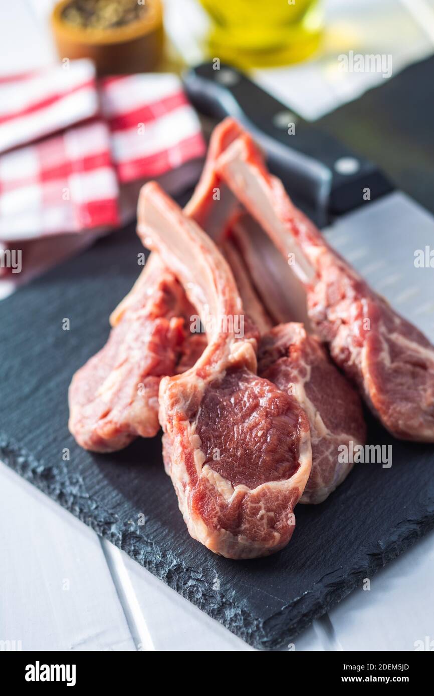 Slices raw lamb chops on stone cutting board Stock Photo