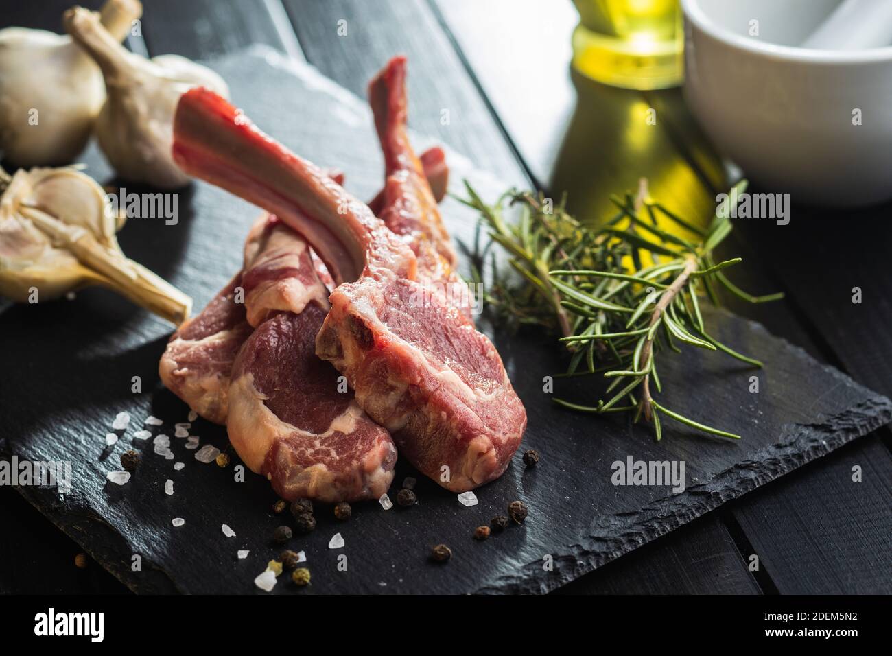 Slices raw lamb chops on black table. Stock Photo