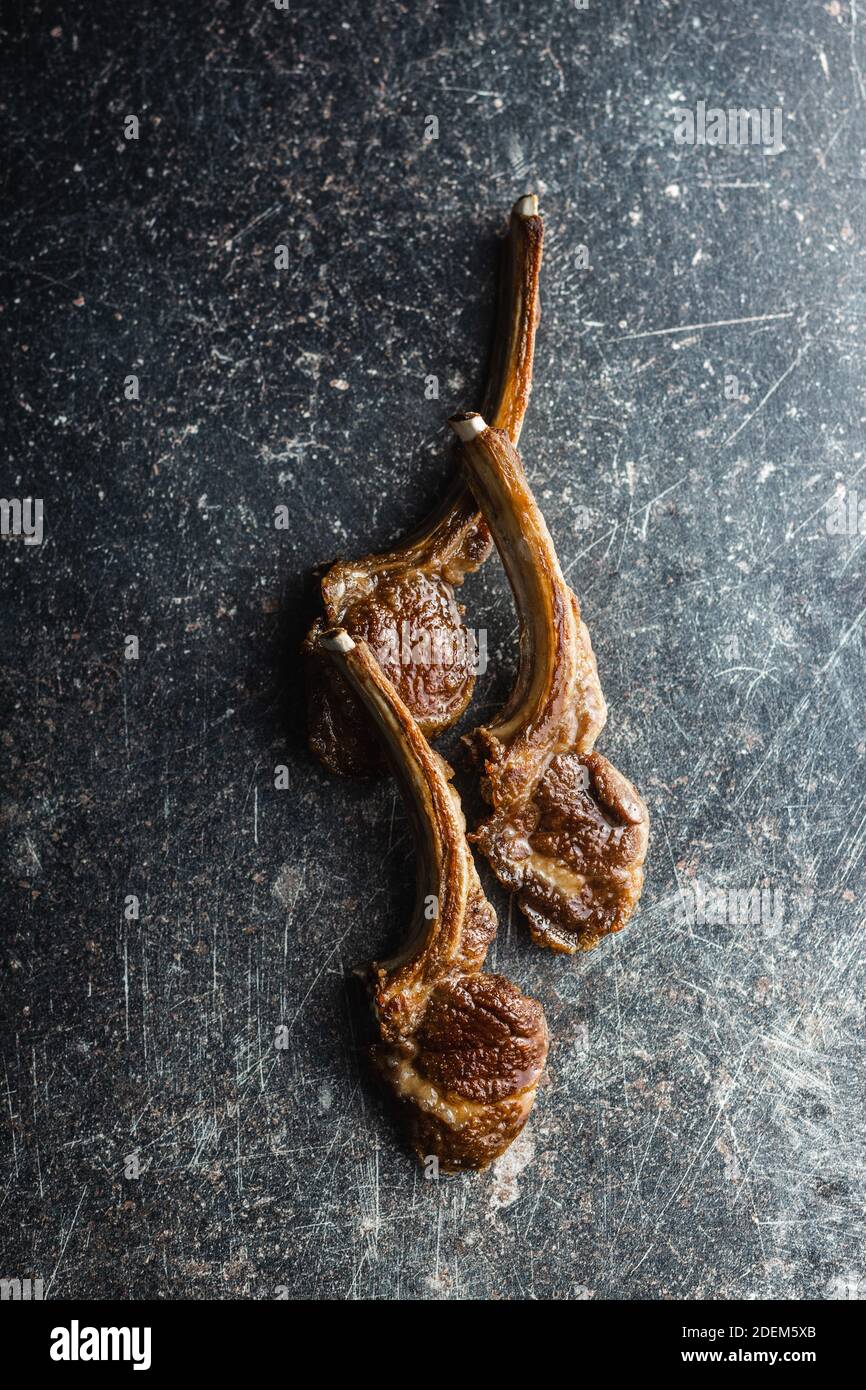 Grilled lamb chops on black table. Top view Stock Photo - Alamy