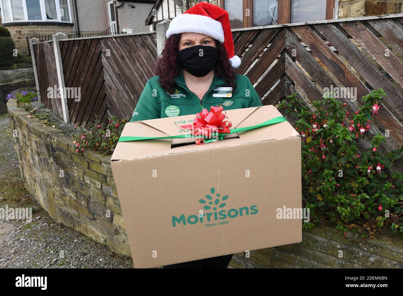 EDITORIAL USE ONLY A staff member delivers ÔThe Christmas Dinner for Two BoxÕ from Morrisons supermarket, which can be ordered from its new dedicated Doorstep Deliveries phone line, enabling vulnerable or self-isolating customers to order their groceries and have them hand-delivered by a colleague from their local store. Stock Photo