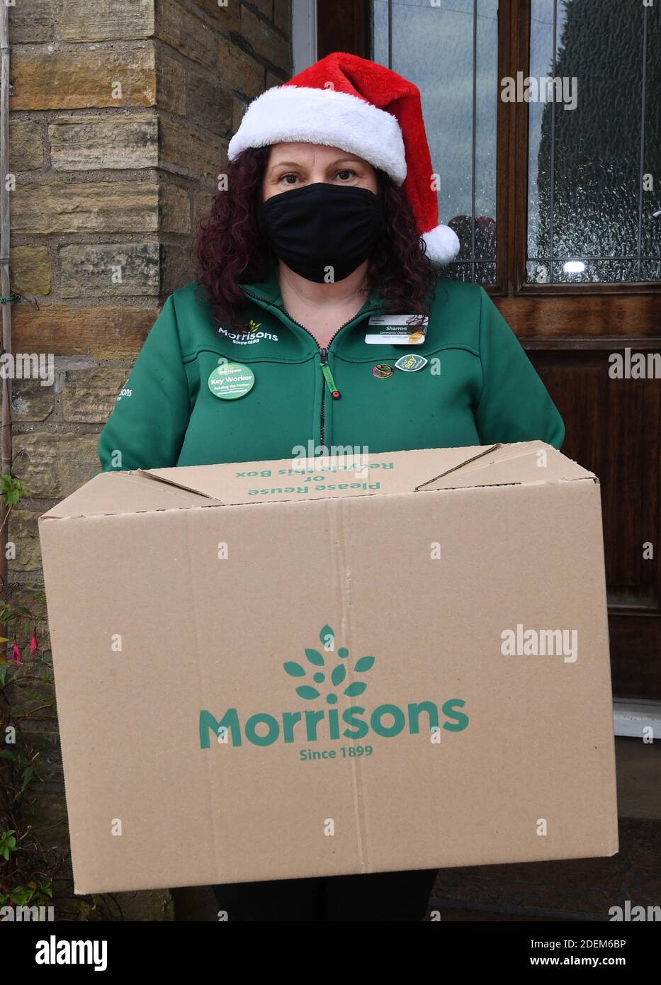 EDITORIAL USE ONLY A staff member delivers ÔThe Christmas Dinner for Two BoxÕ from Morrisons supermarket, which can be ordered from its new dedicated Doorstep Deliveries phone line, enabling vulnerable or self-isolating customers to order their groceries and have them hand-delivered by a colleague from their local store. Stock Photo
