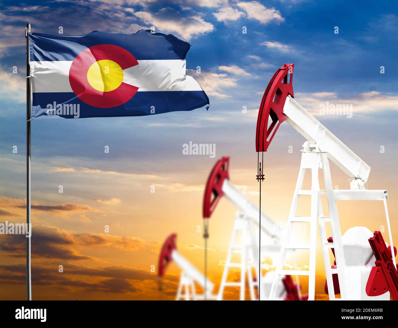 Oil rigs against the backdrop of the colorful sky and a flagpole with ...