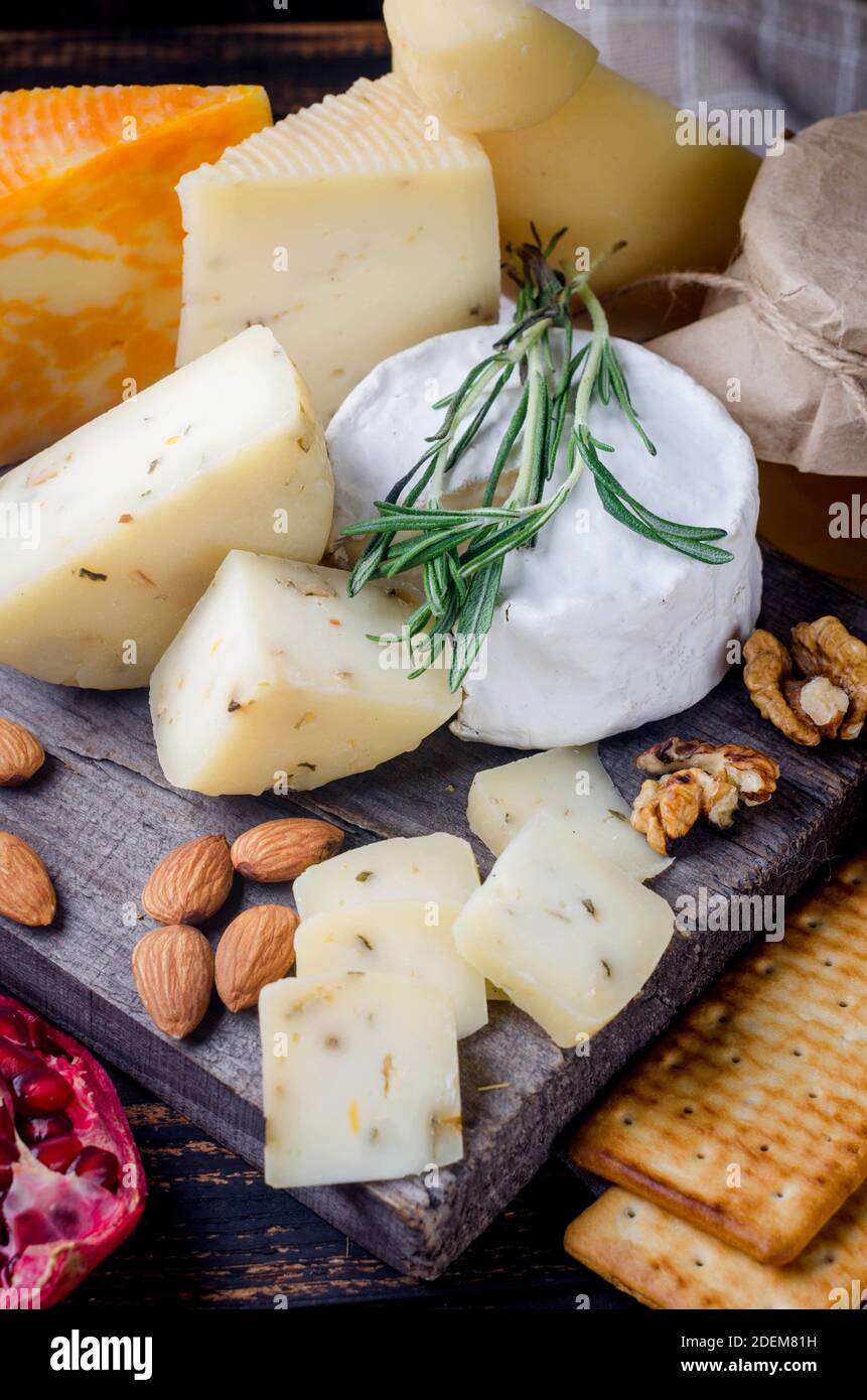 Assorted homemade pieces cheese with honey, fruits, cookies and nuts on table.  Fresh dairy product, healthy organic food. Delicious appetizer. Stock Photo