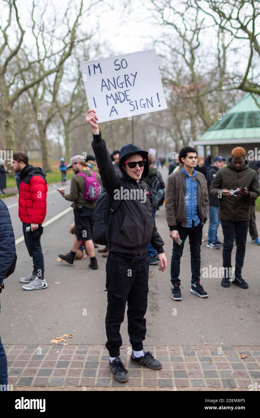 Anti-lockdown protest, Hyde Park, London, 28 November 2020. A protester in sunglasses and hoodie holds up a protest placard. Stock Photo