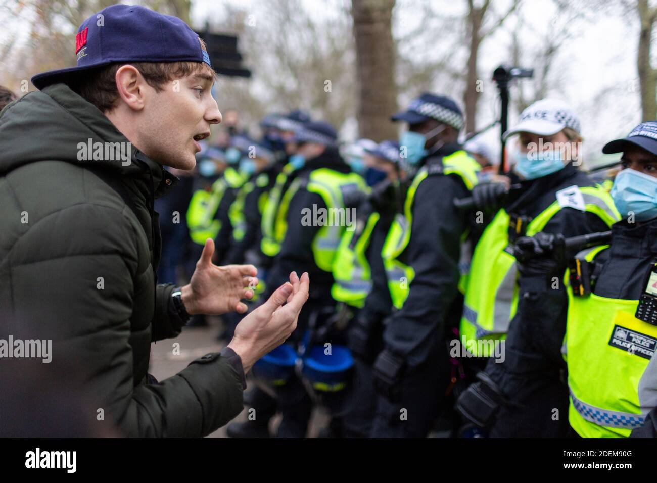 Anti-lockdown protest, Hyde Park, London, 28 November 2020. A protester converses with police officers maintaining a blockade. Stock Photo