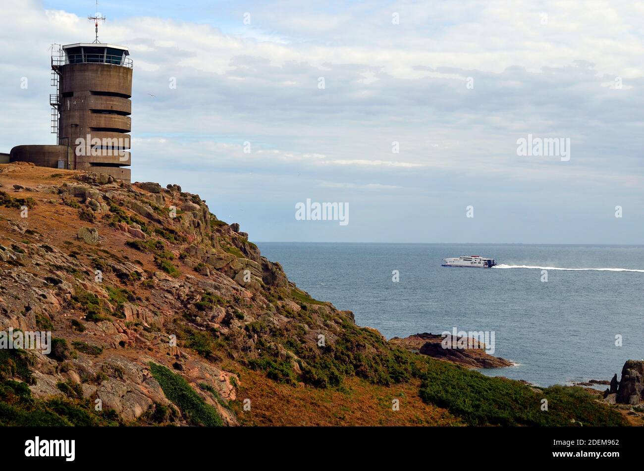 Great Britain, Jersey Island, German watchtower of WWII - now used as transmitting tower and fast ferry in English Channel Stock Photo