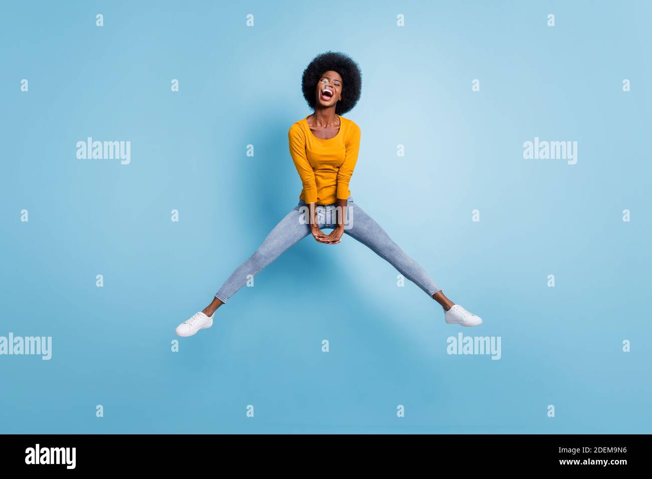 Photo portrait full length of energetic girl jumping up with hands down ...