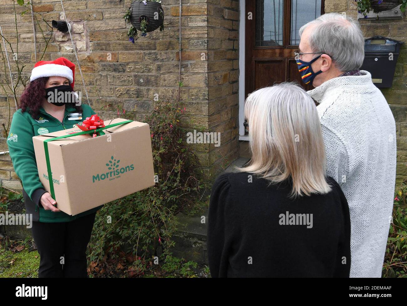 EDITORIAL USE ONLY A staff member delivers 'The Christmas Dinner for Two Box' from Morrisons supermarket, which can be ordered from its new dedicated Doorstep Deliveries phone line, enabling vulnerable or self-isolating customers to order their groceries and have them hand-delivered from their local store. Stock Photo