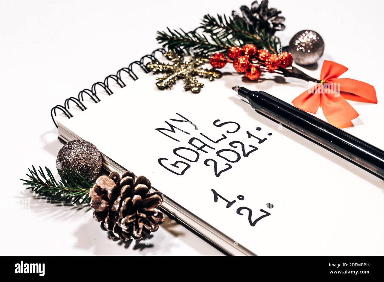 Goals concept. New year 2021 goals list. Notebook and christmas decorations isolated on a white background with copy space. Stock Photo