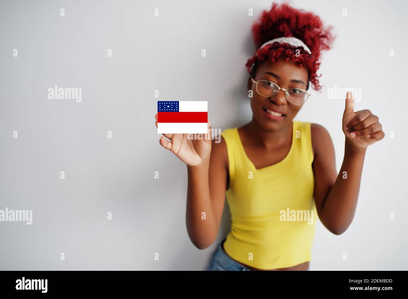 Brazilian woman with afro hair hold Amazonas flag isolated on white background, show thumb up. States of Brazil concept. Stock Photo