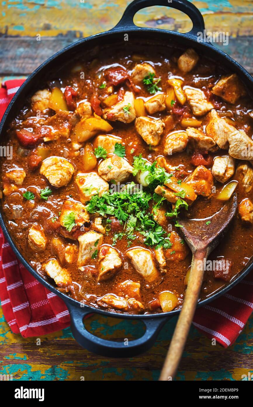 Chicken paneer with indian spices. Chicken pieces with yellow pepper in tomato sauce, parsley. Stock Photo
