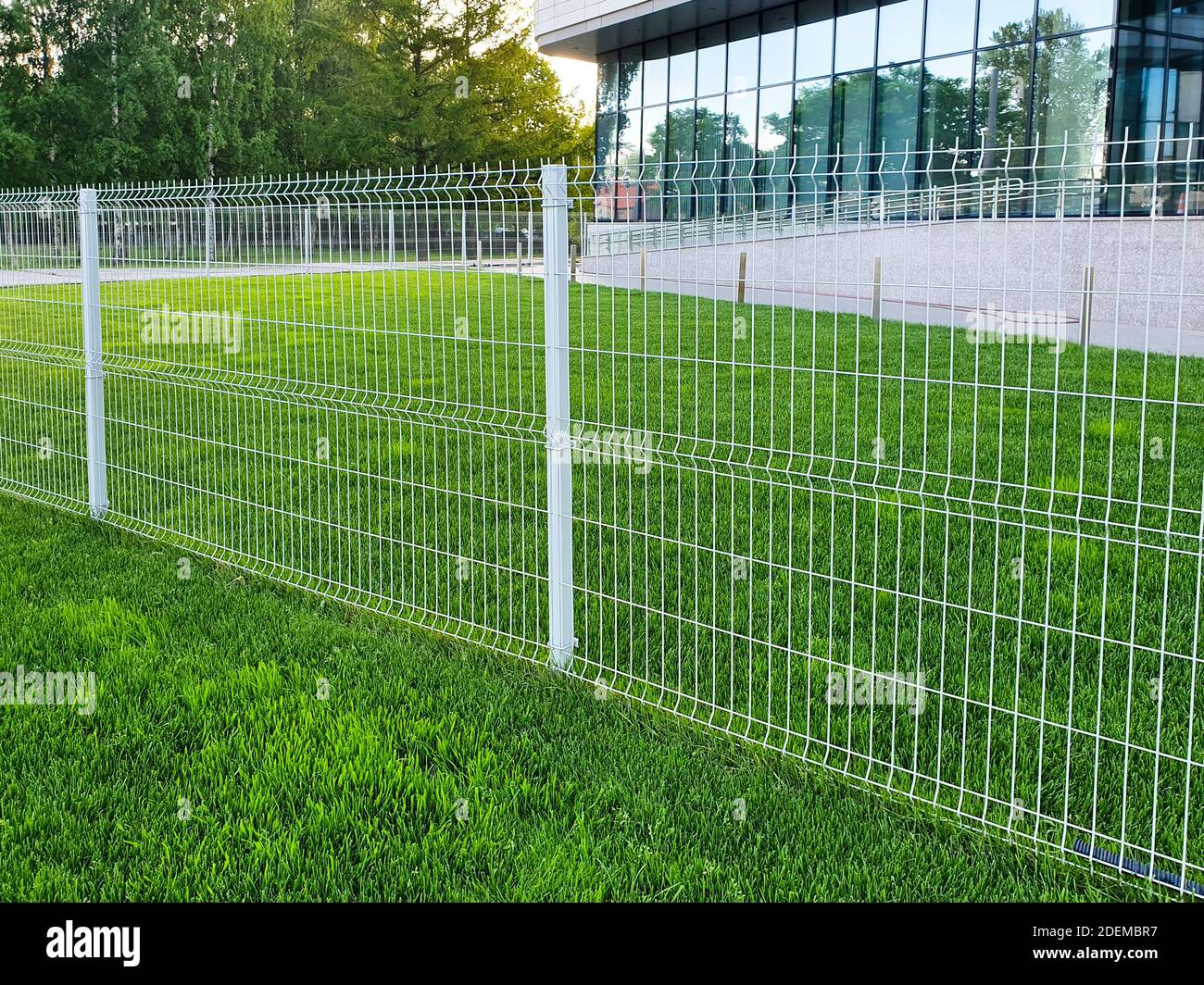 grating wire industrial fence panels, pvc metal fence panel and neatly trimmed lawn Stock Photo