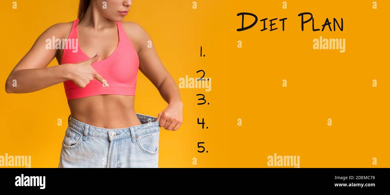 Diet Plan Background With Fit Woman In Oversize Jeans Pointing At Waist Stock Photo