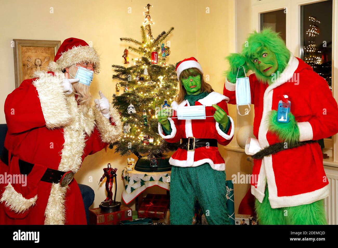 Santa Claus tries to explain to the Grinch and Mrs. Grinch how to wear a protective mask. GEEK ART - Bodypainting and Transformaking: 'The Grinch steals Christmas' photoshooting with Enrico Lein as Grinch, Maria Skupin as Mrs. Grinch and Fabian Zesiger as Santa Claus at the Villa Czarnecki. in Hameln on November 30, 2020 - A project by the photographer Tschiponnique Skupin and the bodypainter Enrico Lein Stock Photo