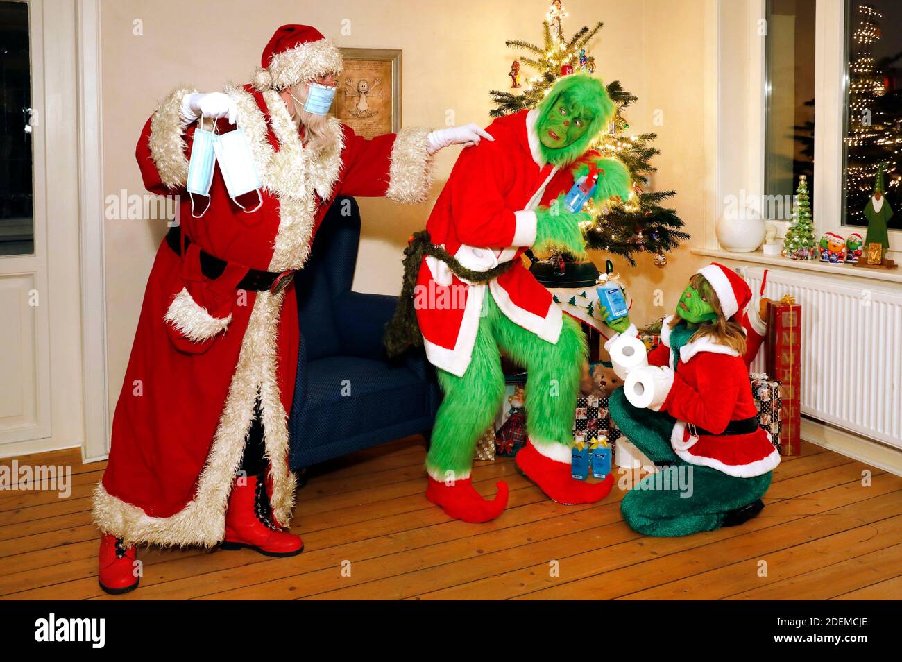 Santa Claus catches the Grinch and Mrs. Grinch stealing presents and tells them to wear a protective mask. GEEK ART - Bodypainting and Transformaking: 'The Grinch steals Christmas' photoshoot with Enrico Lein as Grinch, Maria Skupin as Mrs. Grinch and Fabian Zesiger as Santa Claus at the Villa Czarnecki in Hameln, on November 30, 2020 - A project by the photographer Tschiponnique Skupin and the bodypainter Enrico Lein Stock Photo