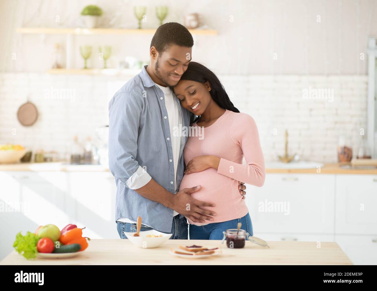 Tender Black Man Touching His Pregnant Wifes Belly While Making Meal