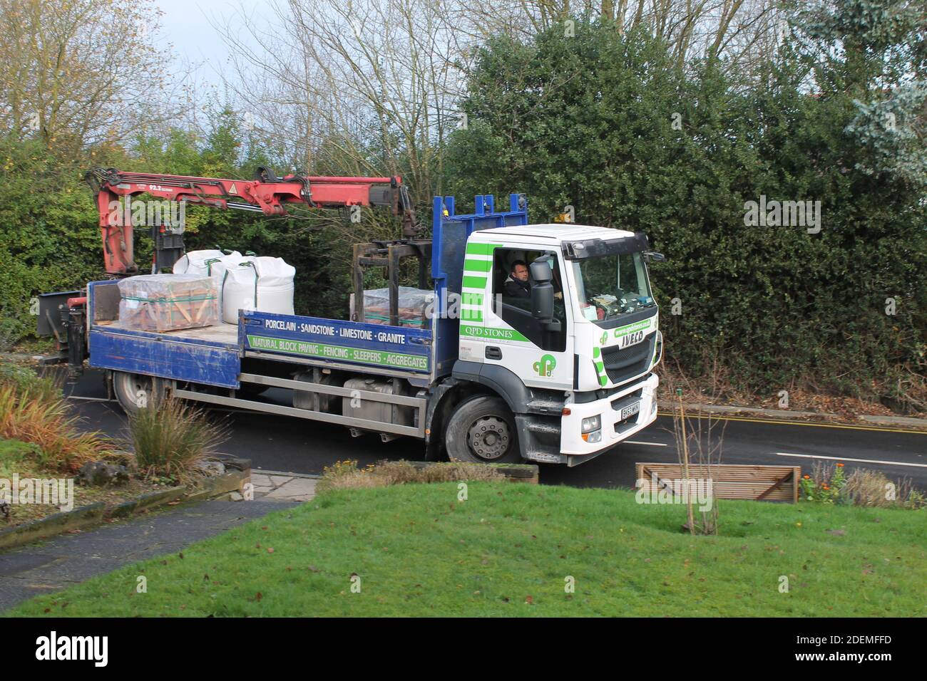 Construction Flat back truck delivering building materials to a domestic house Stock Photo