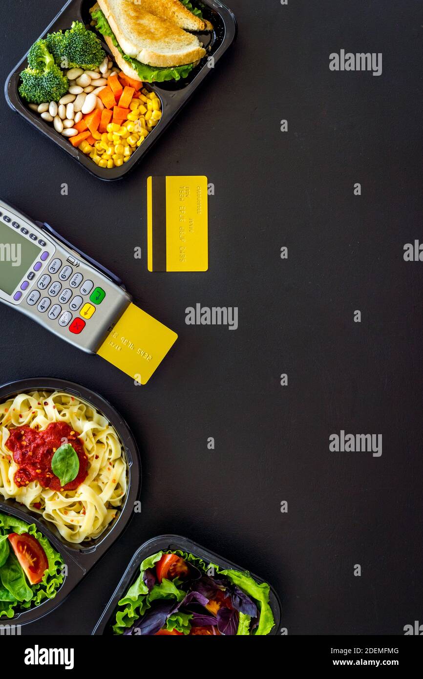Food delivery payment with terminal and lunch boxes with meal Stock