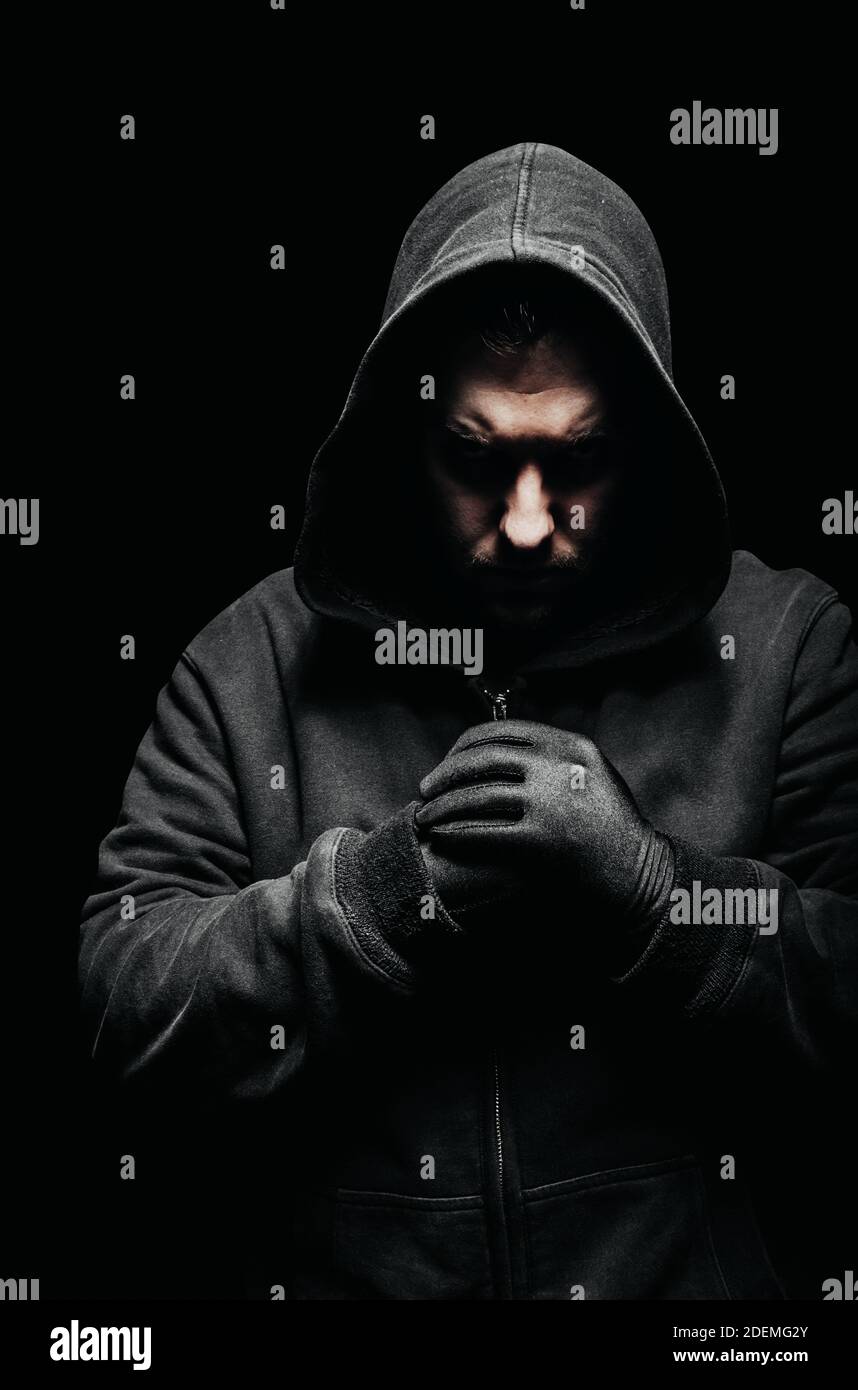 Photo of a creepy vile criminal in hoodie standing in dark Stock Photo -  Alamy